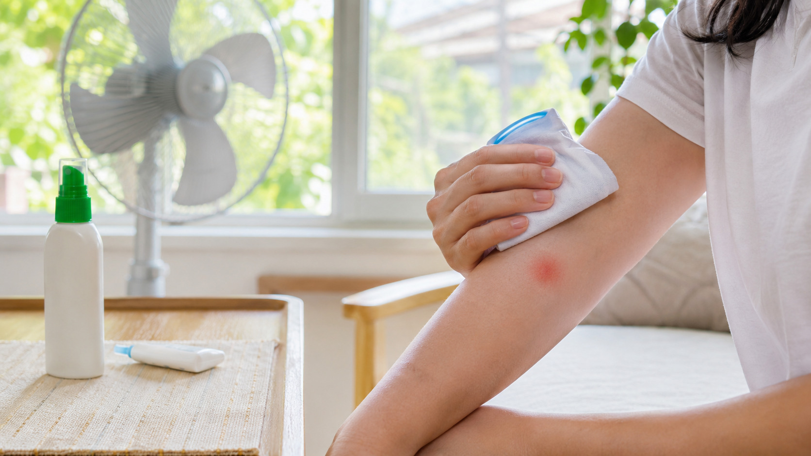 蚊に刺されて赤く腫れた腕を保冷剤で冷やしている様子